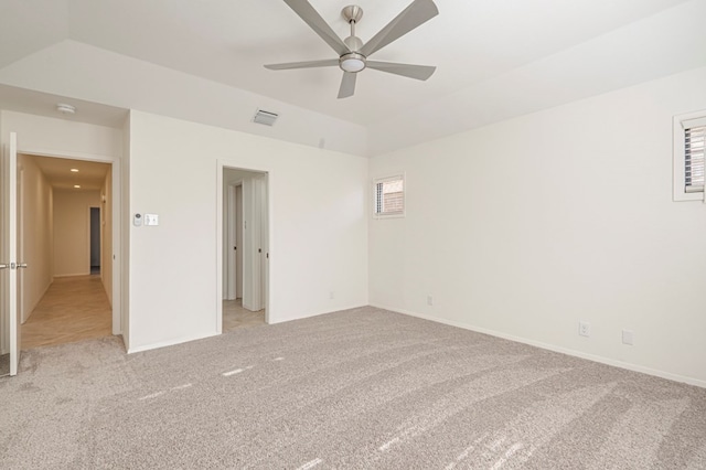 unfurnished room featuring ceiling fan, light carpet, and a tray ceiling