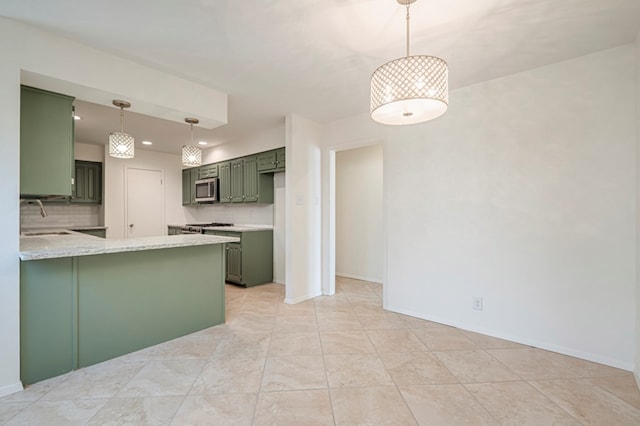 kitchen with pendant lighting, backsplash, green cabinets, sink, and kitchen peninsula