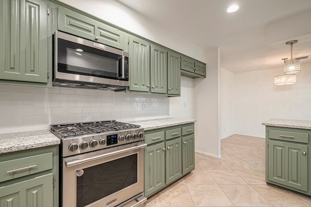 kitchen featuring appliances with stainless steel finishes, tasteful backsplash, light tile patterned floors, decorative light fixtures, and green cabinetry