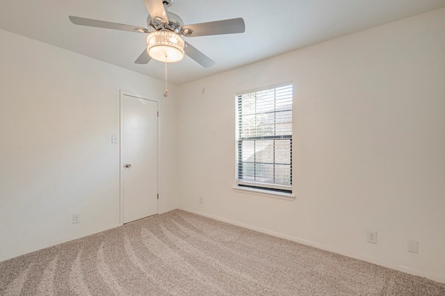 carpeted spare room with ceiling fan