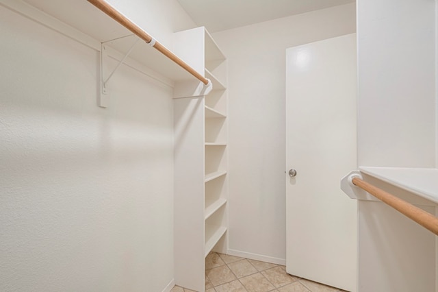 walk in closet with light tile patterned floors