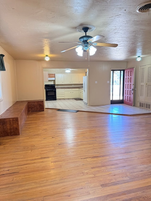 2100 42nd St, Snyder, TX 79549 - unfurnished living room with ceiling fan, light hardwood / wood-style flooring, and a textured ceiling