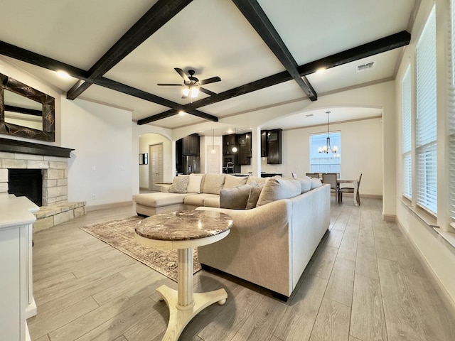 living room with beam ceiling, light hardwood / wood-style flooring, and a healthy amount of sunlight