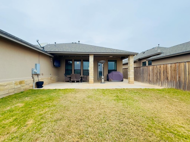 back of house with a patio area and a yard