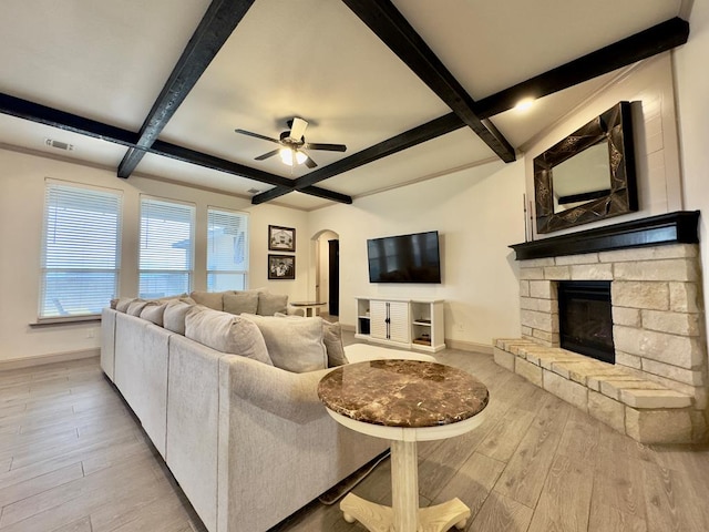 living room with beam ceiling, ceiling fan, coffered ceiling, a fireplace, and light wood-type flooring