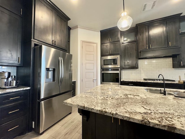 kitchen with sink, hanging light fixtures, light hardwood / wood-style flooring, tasteful backsplash, and stainless steel appliances