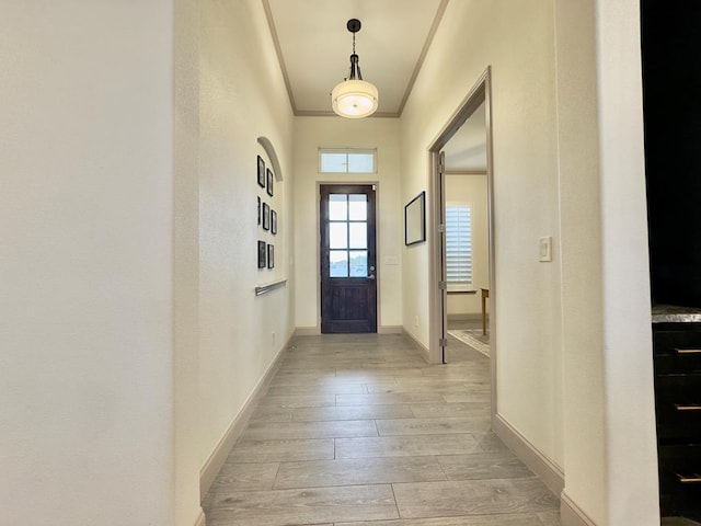 entryway featuring crown molding and light wood-type flooring