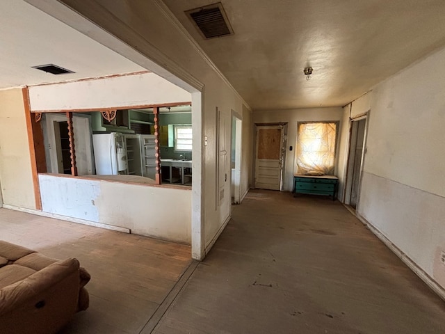 hall with unfinished concrete floors and visible vents