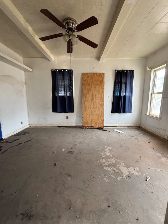 empty room featuring unfinished concrete floors, a ceiling fan, and beam ceiling