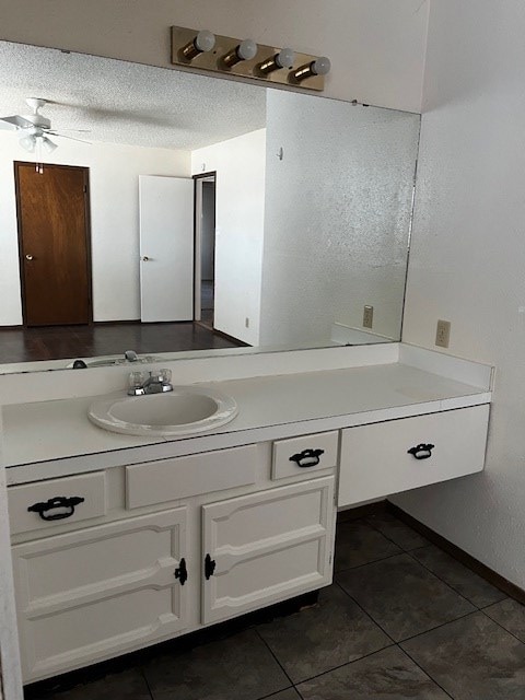 bathroom featuring ceiling fan, tile patterned floors, a textured ceiling, and vanity