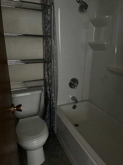 bathroom with toilet, tile patterned floors, and shower / bath combo with shower curtain