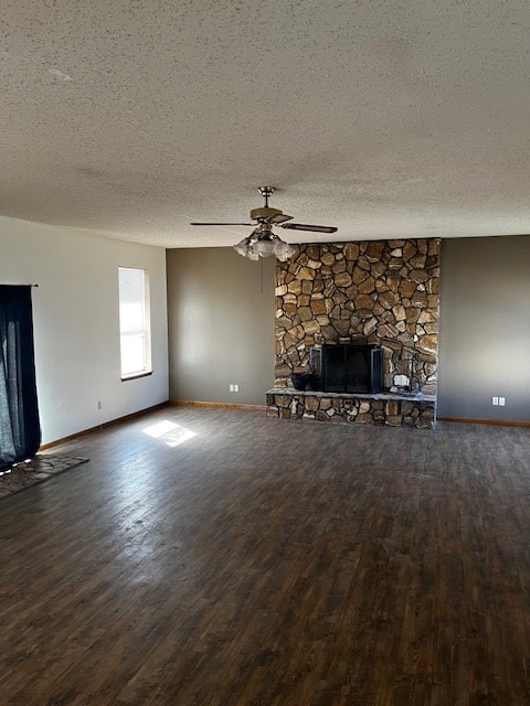 unfurnished living room with a textured ceiling, ceiling fan, hardwood / wood-style floors, and a fireplace