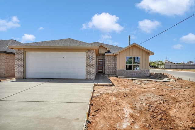single story home with concrete driveway, board and batten siding, an attached garage, brick siding, and a shingled roof