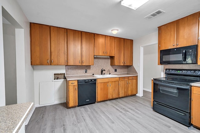 3404 W Michigan Ave, Midland, TX 79703 - kitchen featuring black appliances, a sink, light countertops, and light wood-type flooring