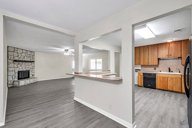 3404 W Michigan Ave, Midland, TX 79703 - kitchen with dishwasher, a sink, light wood-style floors, brown cabinets, and ceiling fan