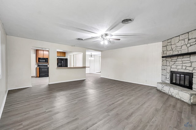 3404 W Michigan Ave, Midland, TX 79703 - unfurnished living room with a ceiling fan, a stone fireplace, dark wood finished floors, baseboards, and a chandelier