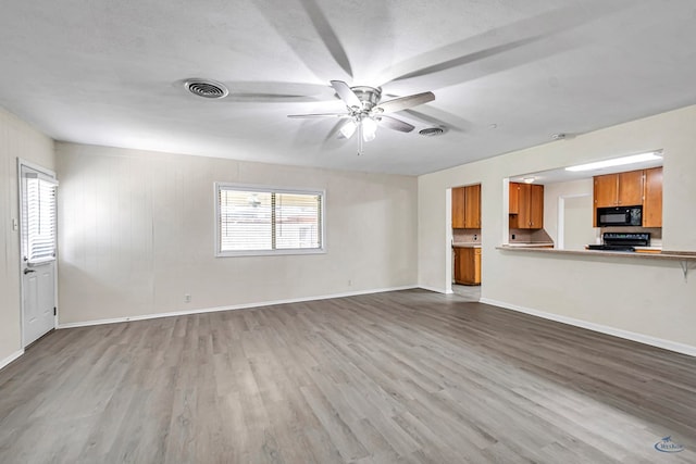 3404 W Michigan Ave, Midland, TX 79703 - unfurnished living room featuring wood finished floors, a ceiling fan, and baseboards