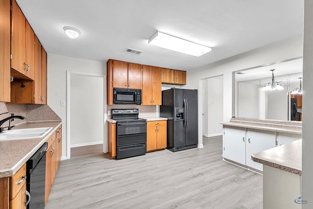 3404 W Michigan Ave, Midland, TX 79703 - kitchen with black appliances, a sink, tasteful backsplash, and light wood-type flooring
