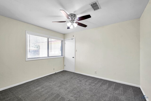 3404 W Michigan Ave, Midland, TX 79703 - spare room featuring dark carpet, a ceiling fan, and baseboards