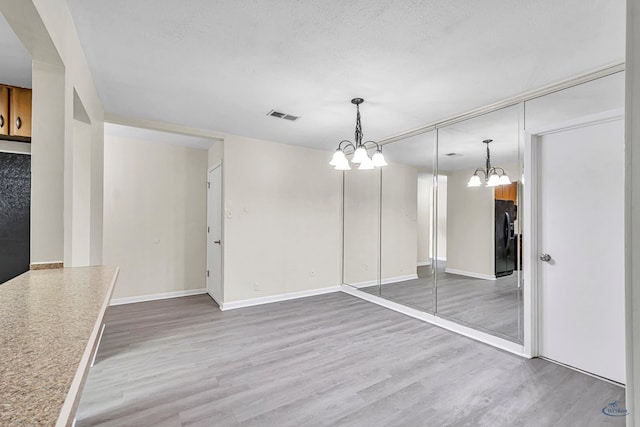 3404 W Michigan Ave, Midland, TX 79703 - unfurnished dining area with a chandelier, wood finished floors, and baseboards