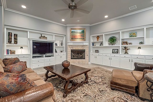 living room with built in shelves, ceiling fan, a fireplace, and crown molding