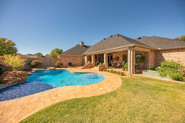 view of swimming pool with an in ground hot tub, a patio, and a lawn