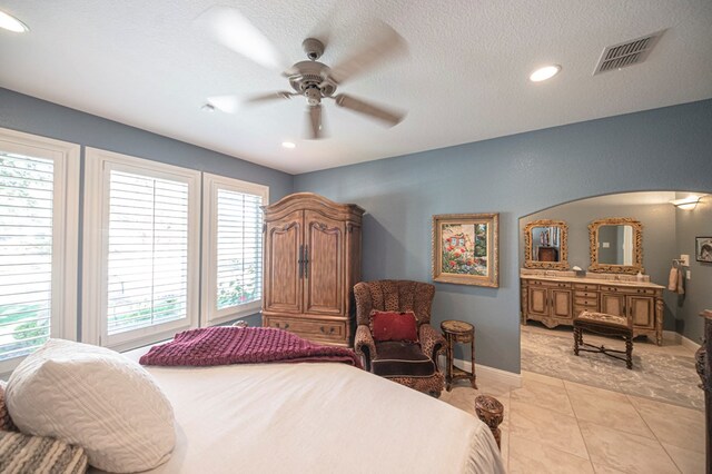 tiled bedroom with a textured ceiling and ceiling fan