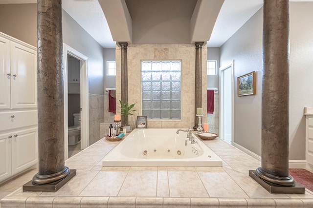 bathroom featuring tiled bath and toilet