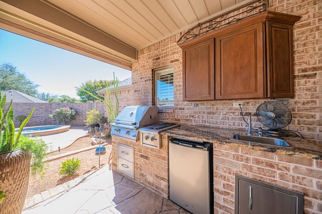 view of patio featuring area for grilling, exterior kitchen, sink, and a swimming pool