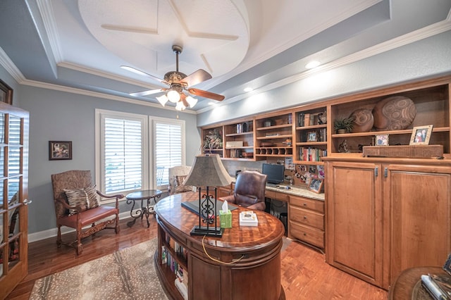 office space featuring a tray ceiling, ceiling fan, light hardwood / wood-style flooring, and ornamental molding