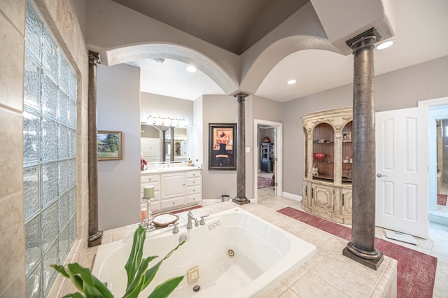 bathroom featuring tile patterned flooring, vanity, tiled tub, and decorative columns