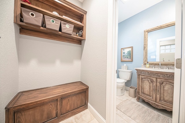 bathroom featuring tile patterned flooring, vanity, and toilet