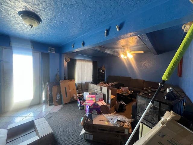 1603 5th St, Big Spring, TX 79720 - living area featuring a ceiling fan, a textured ceiling, and tile patterned flooring
