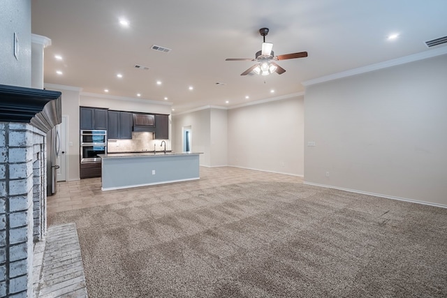 unfurnished living room with sink, light colored carpet, and ornamental molding