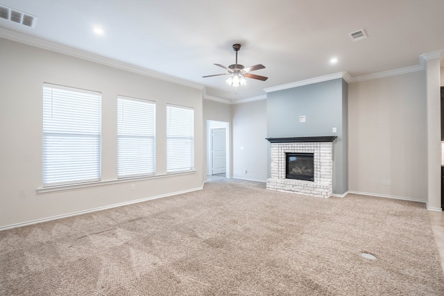 unfurnished living room featuring light carpet, ceiling fan, crown molding, and a fireplace