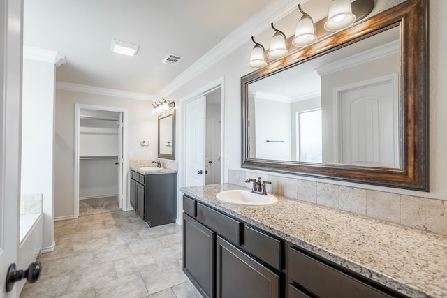 bathroom with vanity, crown molding, and a tub to relax in