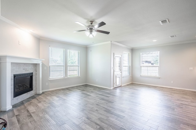 1212 Santa Clara, Midland, TX 79705 - unfurnished living room with a ceiling fan, plenty of natural light, a glass covered fireplace, wood finished floors, and crown molding