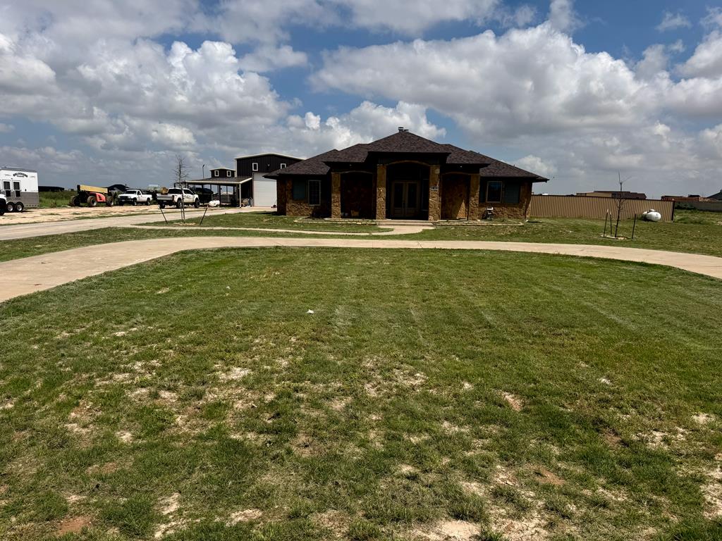 3701 Timber Wolf Trl, Midland, TX 79706 - prairie-style home with curved driveway, a front yard, brick siding, and a garage