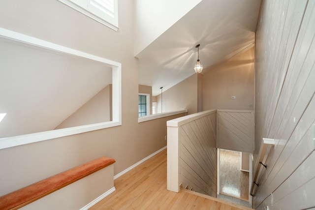 staircase featuring wood-type flooring and vaulted ceiling