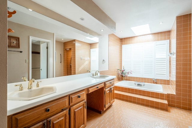 bathroom with separate shower and tub, vanity, a skylight, and tile walls