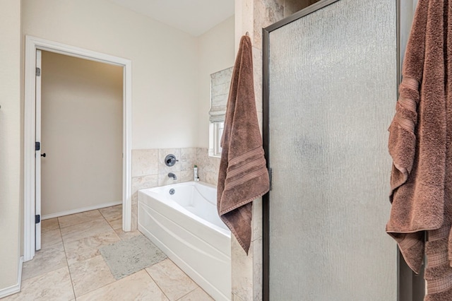 full bathroom with a shower stall, baseboards, and a bath