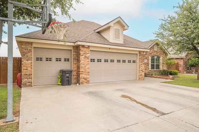 view of front of house featuring fence, concrete driveway, an attached garage, brick siding, and roof with shingles