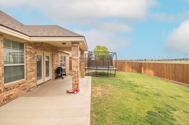 view of yard with a trampoline, a patio area, and a fenced backyard