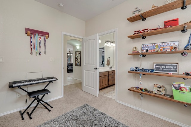 interior space featuring arched walkways, light carpet, and a sink