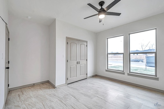 unfurnished bedroom featuring multiple windows, ceiling fan, and a closet