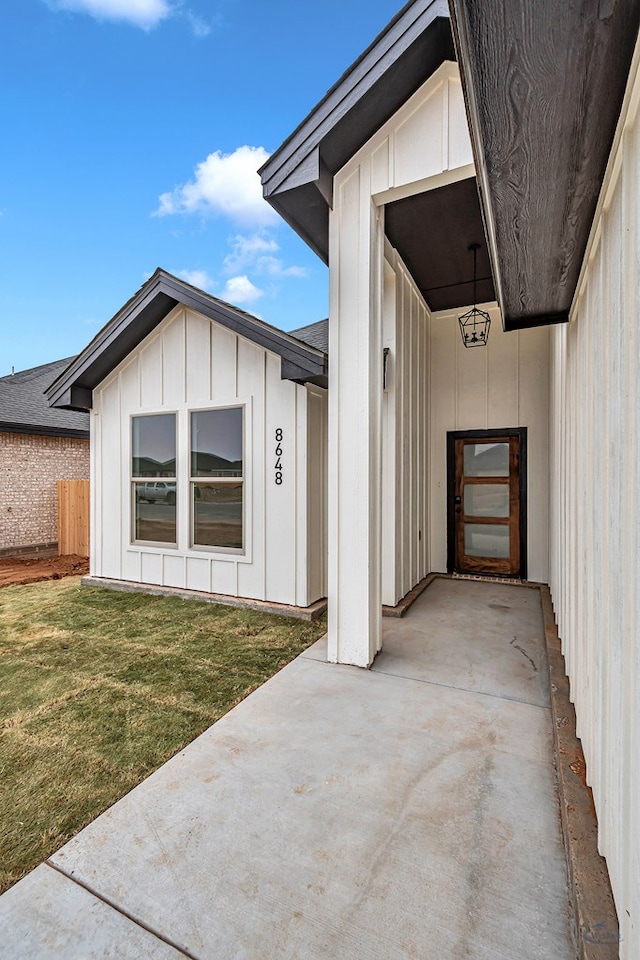 doorway to property with a patio and a lawn