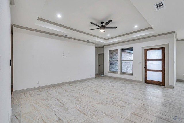 spare room featuring a tray ceiling and ceiling fan