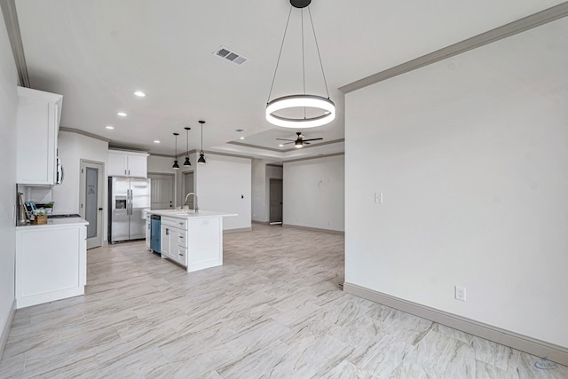 kitchen featuring sink, decorative light fixtures, a center island with sink, a raised ceiling, and stainless steel appliances