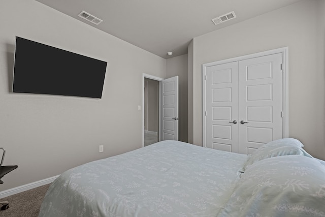 bedroom featuring a closet, carpet, visible vents, and baseboards