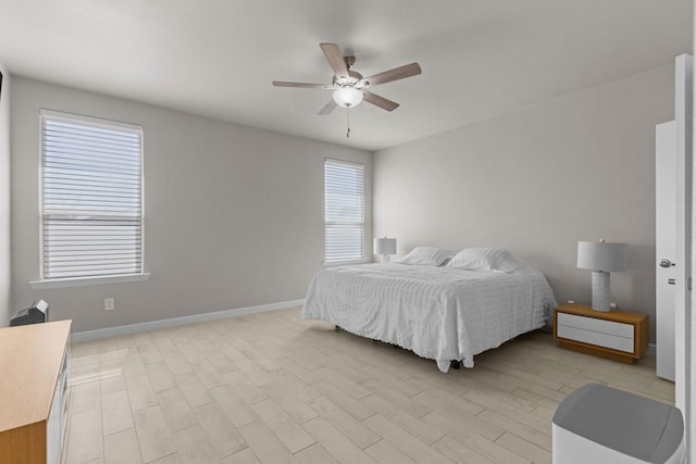 bedroom featuring light wood finished floors, ceiling fan, and baseboards